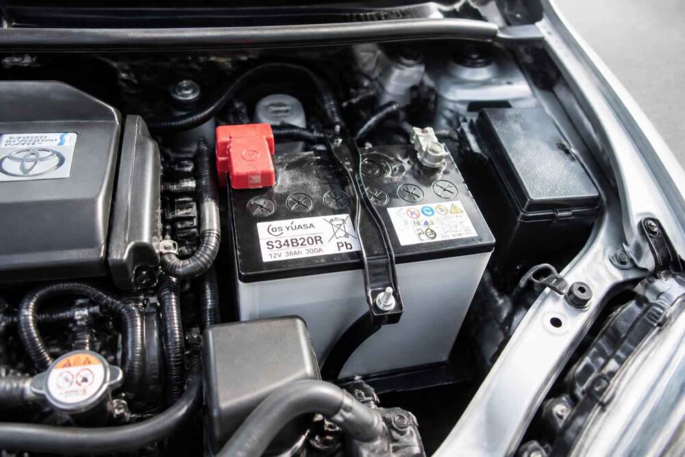 Akumulator samochodowy z czerwonym zaciskiem w komorze silnika Toyoty