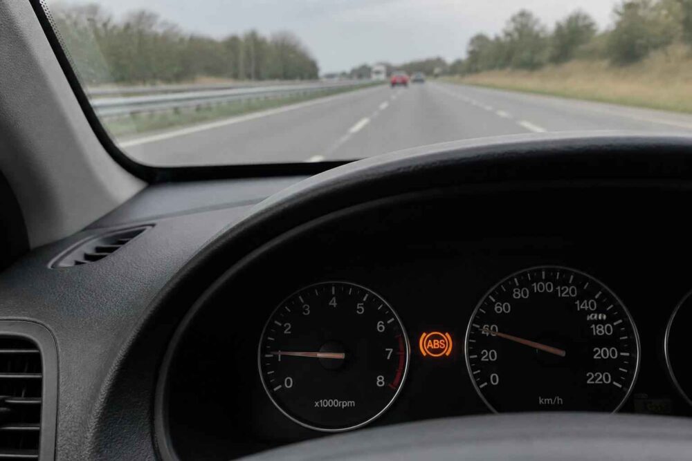 Pomarańczowa kontrolka ABS na desce rozdzielczej podczas jazdy autostradą